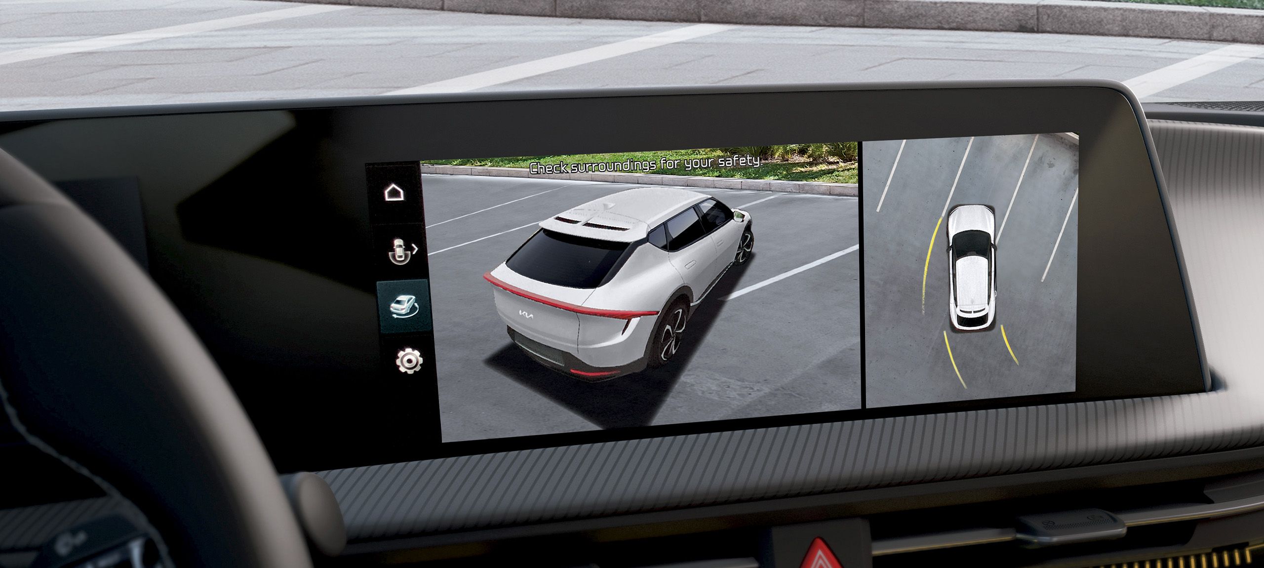 Close-up image of the central console inside the 2026 Kia EV6, highlighting the 360 degree surround view monitor, displaying an aerial view of the vehicle's surroundings.
