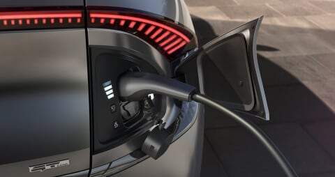 Kia electric car external socket plugged into plug-in charging cable 