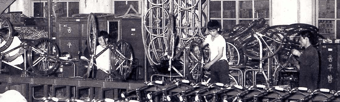 Factory workers constructing bicycles