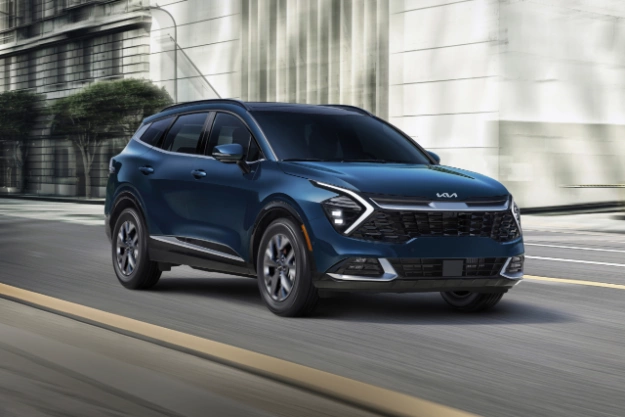 2024 Kia Sportage Hybrid in blue, driving through the city in a three-quarter front view