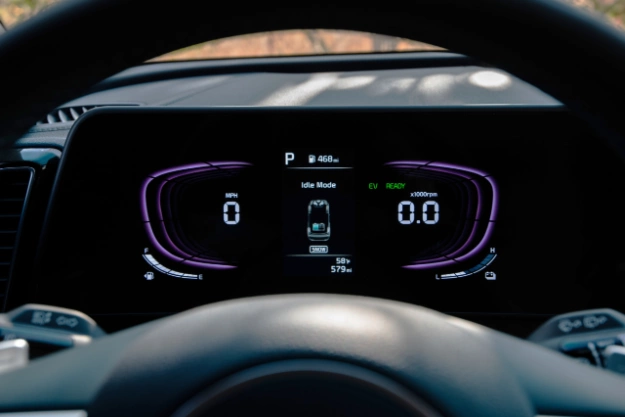 2024 Kia Sportage Hybrid interior, zoomed in on the driver's digital dashboard, highlighting the speed metrics, gas indicator, mileage, outside temperature, and power mode