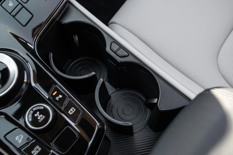 2024 Kia Sportage Hybrid interior zoomed in on the center console, featuring two large cupholders