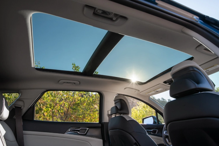 2024 Kia Sportage Hybrid interior,  side view of the second row, featuring a panoramic sunroof above the driver and second row seats