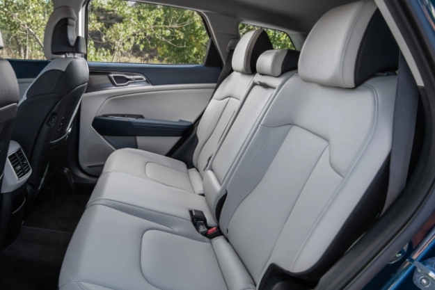 2024 Kia Sportage Hybrid in light grey, three-quarter view of the second row, featuring light grey leather seats