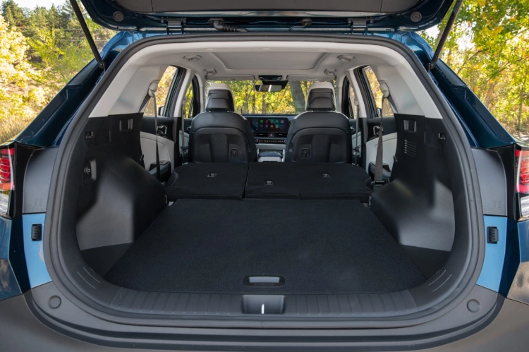 Interior del Kia Sportage Hybrid 2024, vista trasera, con un amplio espacio de almacenamiento con la segunda fila de asientos plegados