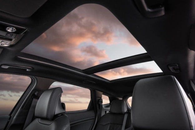 2024 Kia Sportage Plug-in Hybrid interior, roof angled view featuring the panoramic sunroof on a cloudy day during sunset