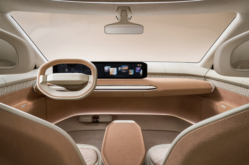Interior del Kia EV4, vista del conductor y el pasajero, con un tablero minimalista con panel digital panorámico y volante geométrico