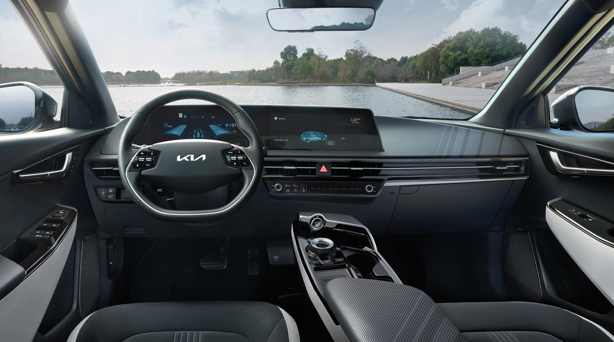 A photo of the black and sleek interior of the 2023 Kia EV6 parked in front of a large body of water