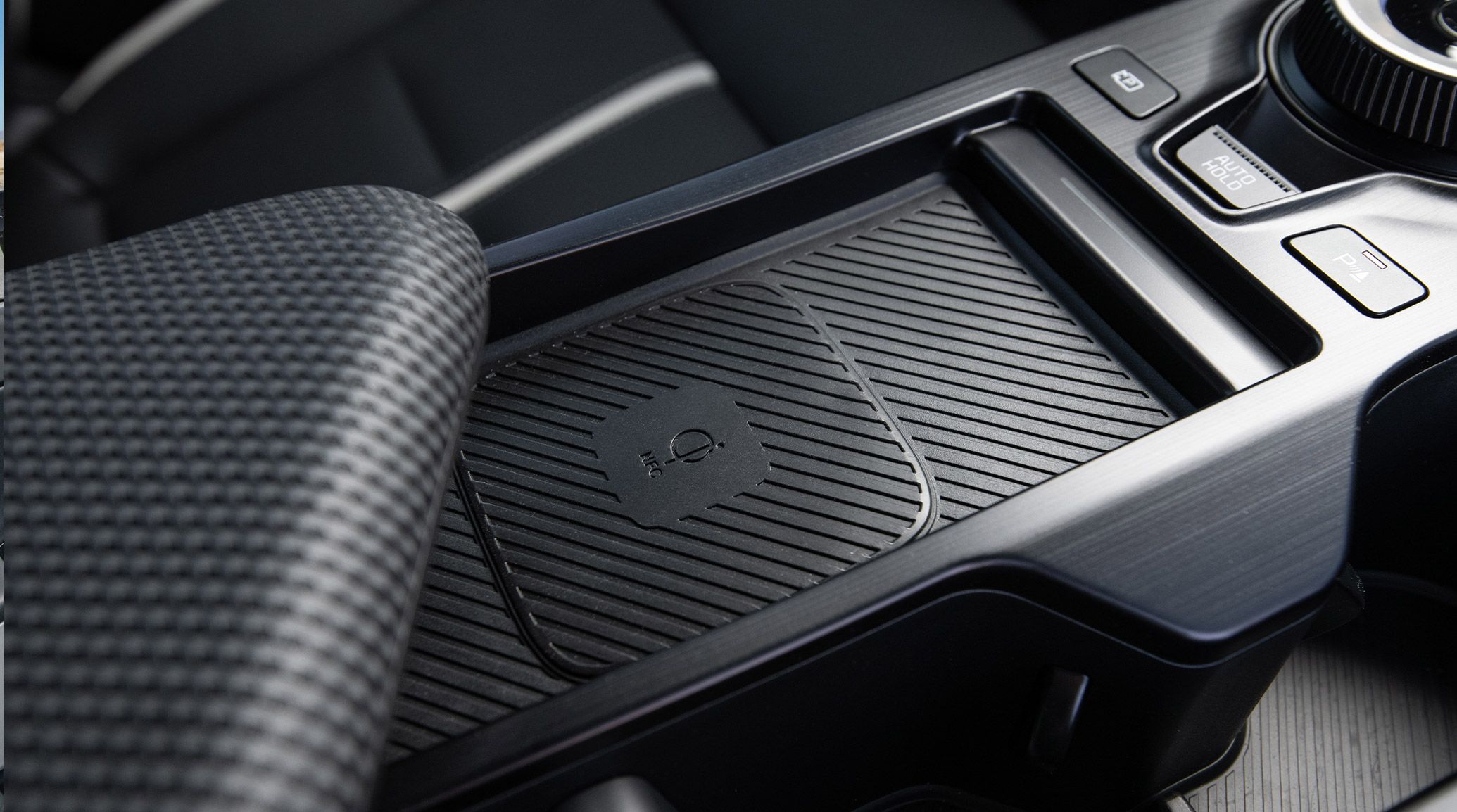 Close-up shot inside the 2026 Kia EV6 electric CUV showing the available integrated wireless phone charging surface in the GT-Line AWD trim.