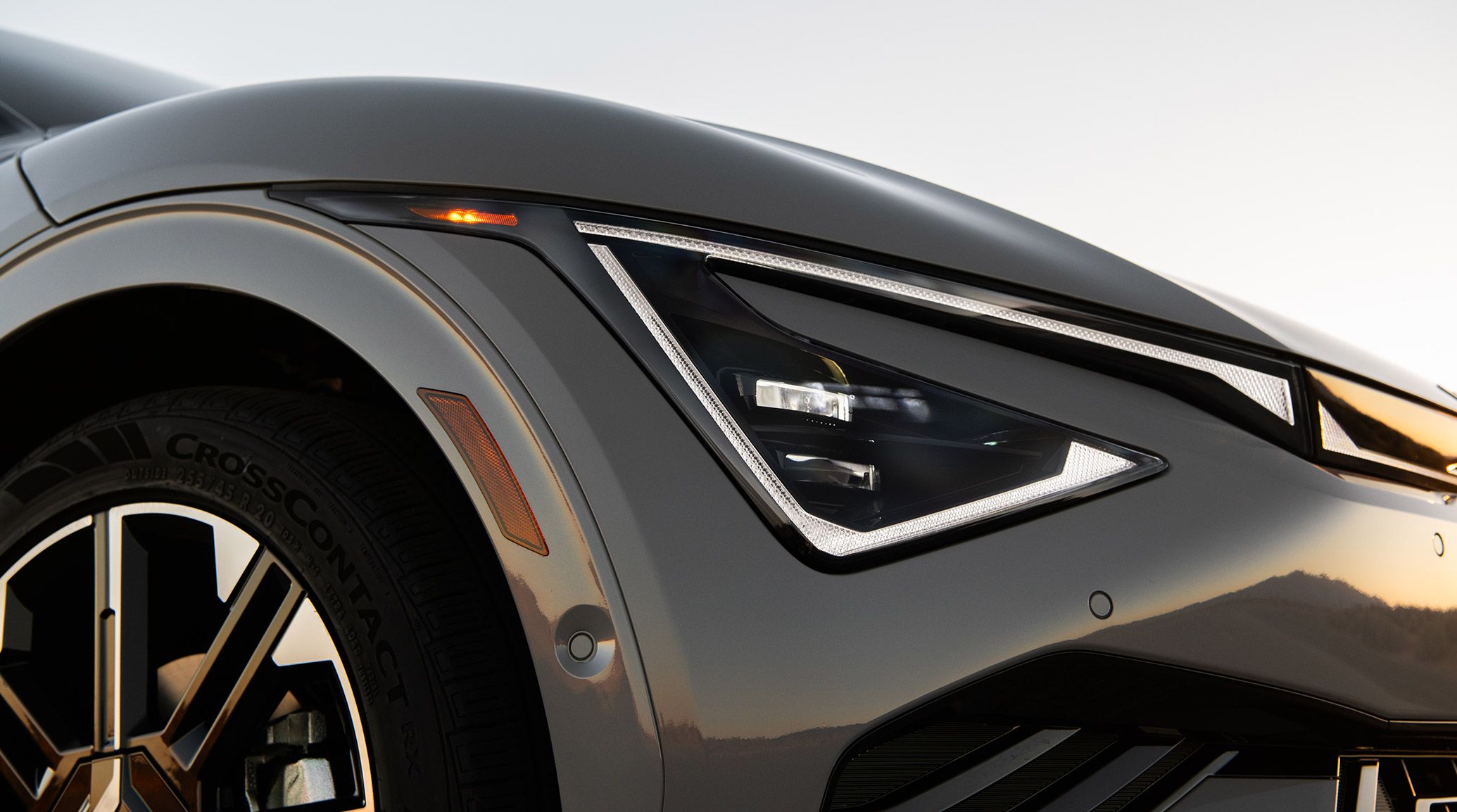 Close up photograph of the 2026 Kia EV6 electric CUV highlighting its distinctively-shaped LED projector headlights, with sharp lines and angles.