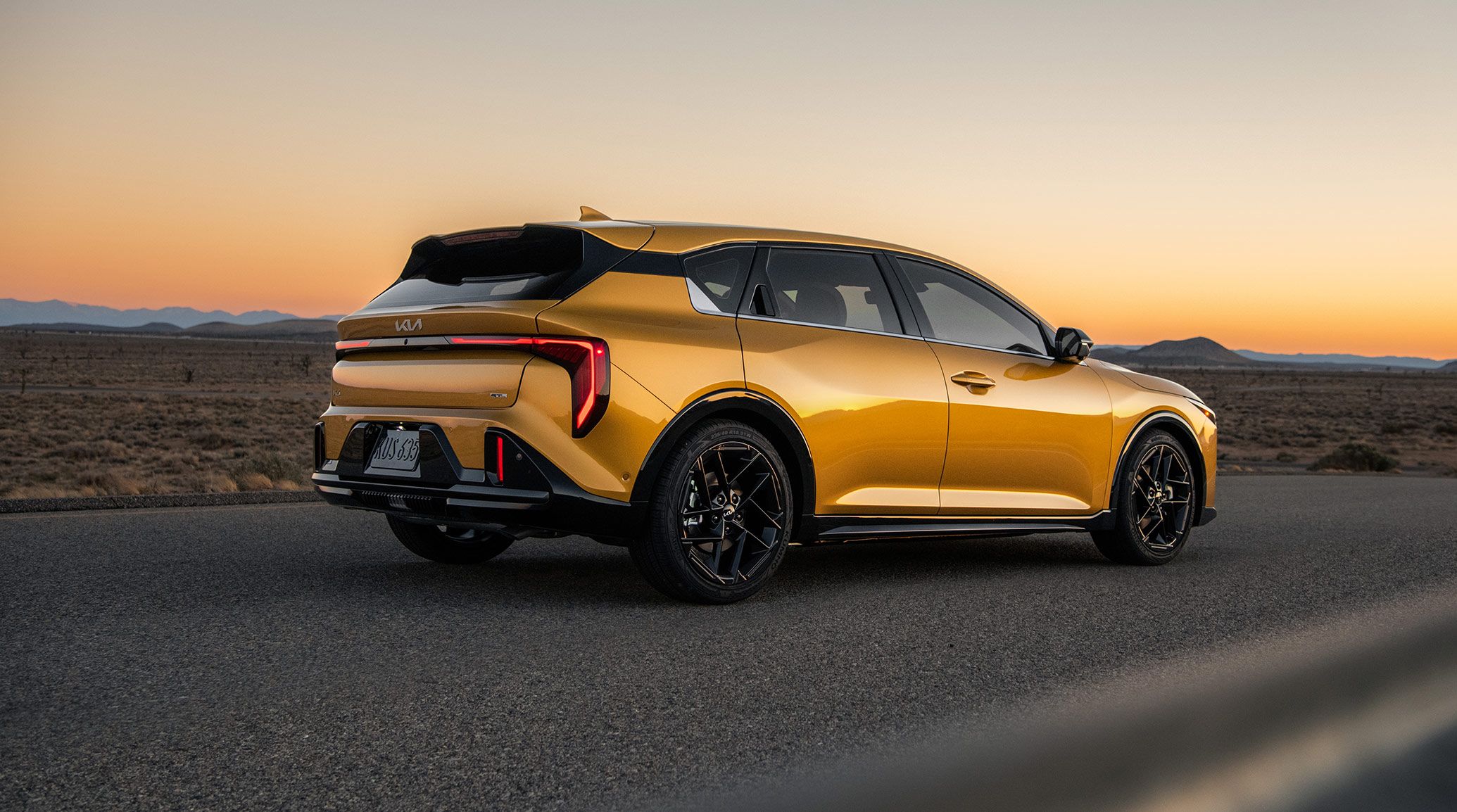 Standing Shot of the 2026 K4 Hatchback GT-Line Turbo in the desert with the emphasis on showing the Floating Roof Design.