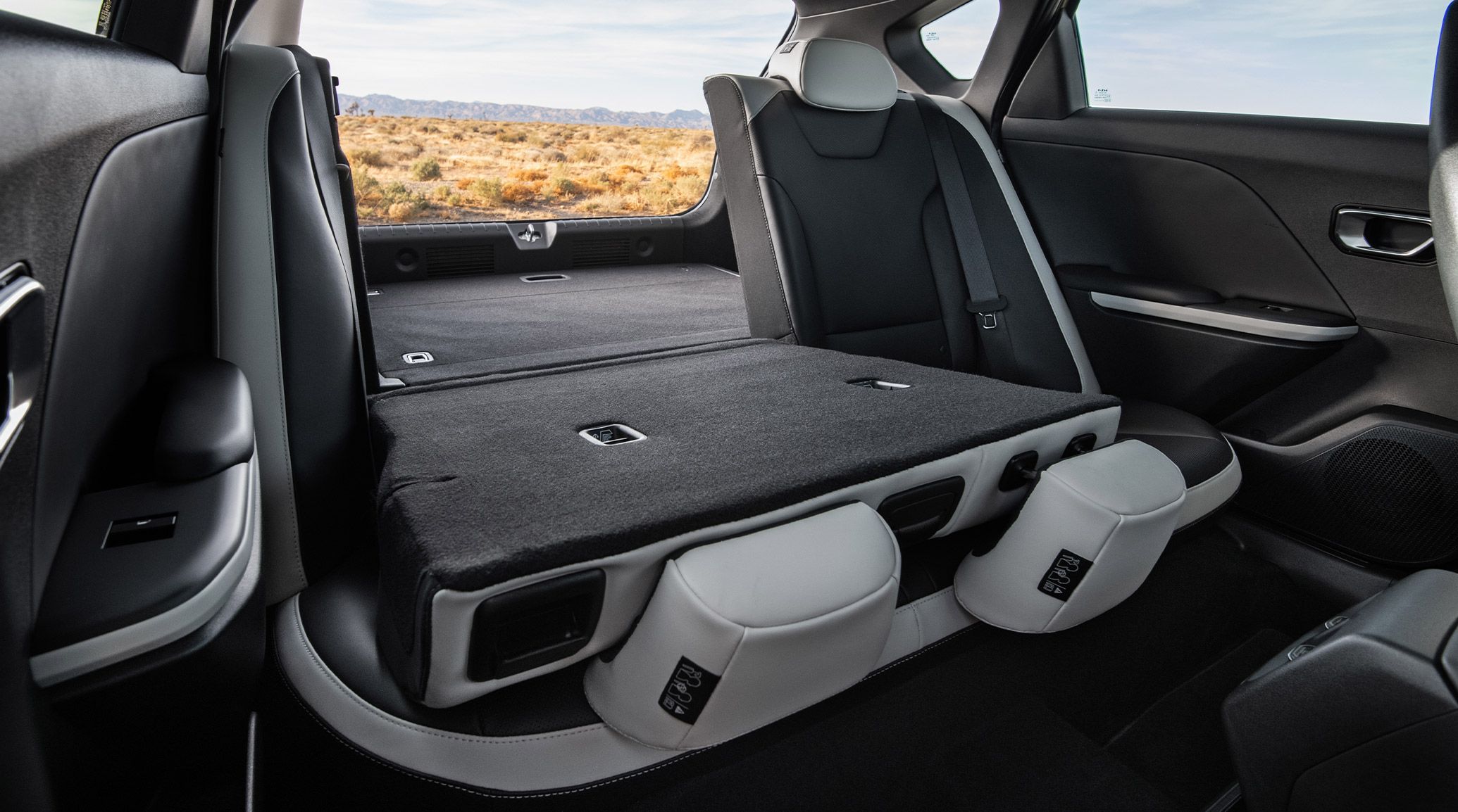 An interior shot of the back seats of the 2026 K4 Hatchback GT-Line Turbo with the seat down and trunk open to highlight the 60/40 split-folding rear seats.