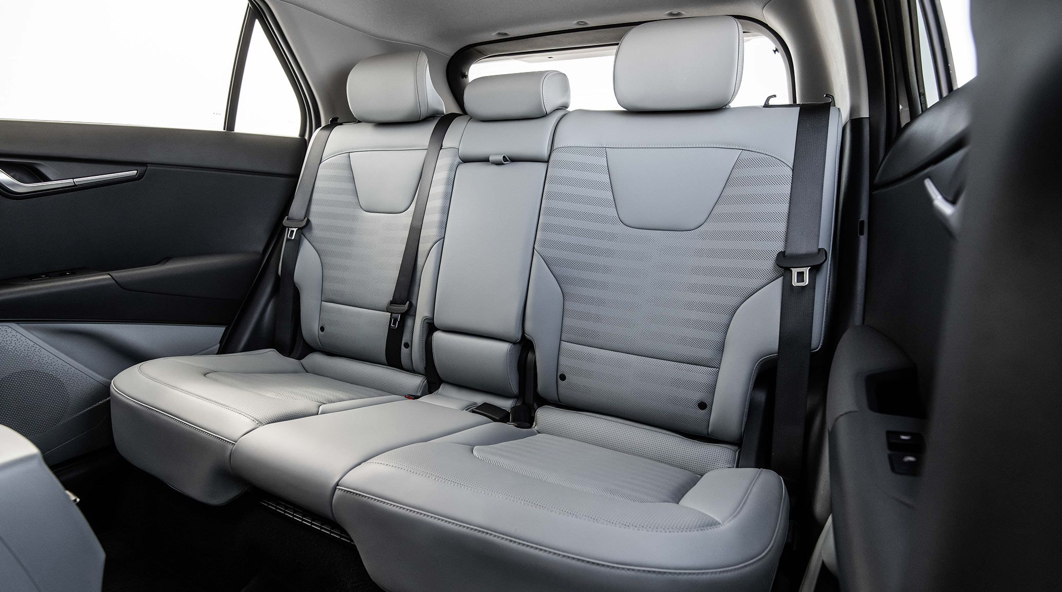 Interior view of the 2027 Kia Niro Hybrid Electric SUV featuring its second-row seating in grey fabric and ample leg space for backseat passengers.