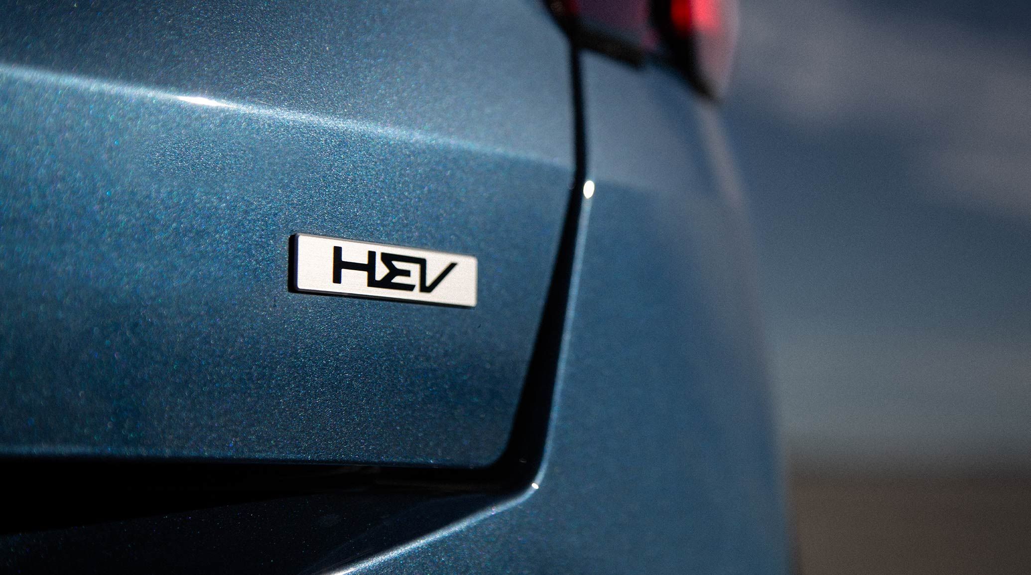 2026 Kia Sorento Hybrid in blue, zoomed in view of the trunk door to reveal the HEV emblem