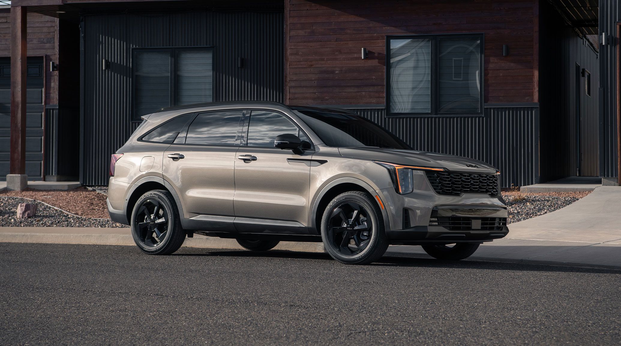 كيا سورينتو Plug-in Hybrid 2026 من الأمام بثلاثة أرباع أمام منزل