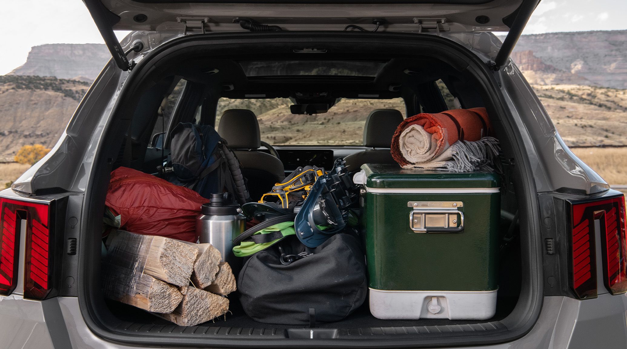Kia Sorento SX in Wolf Gray with the trunk open, filled with camping supplies.