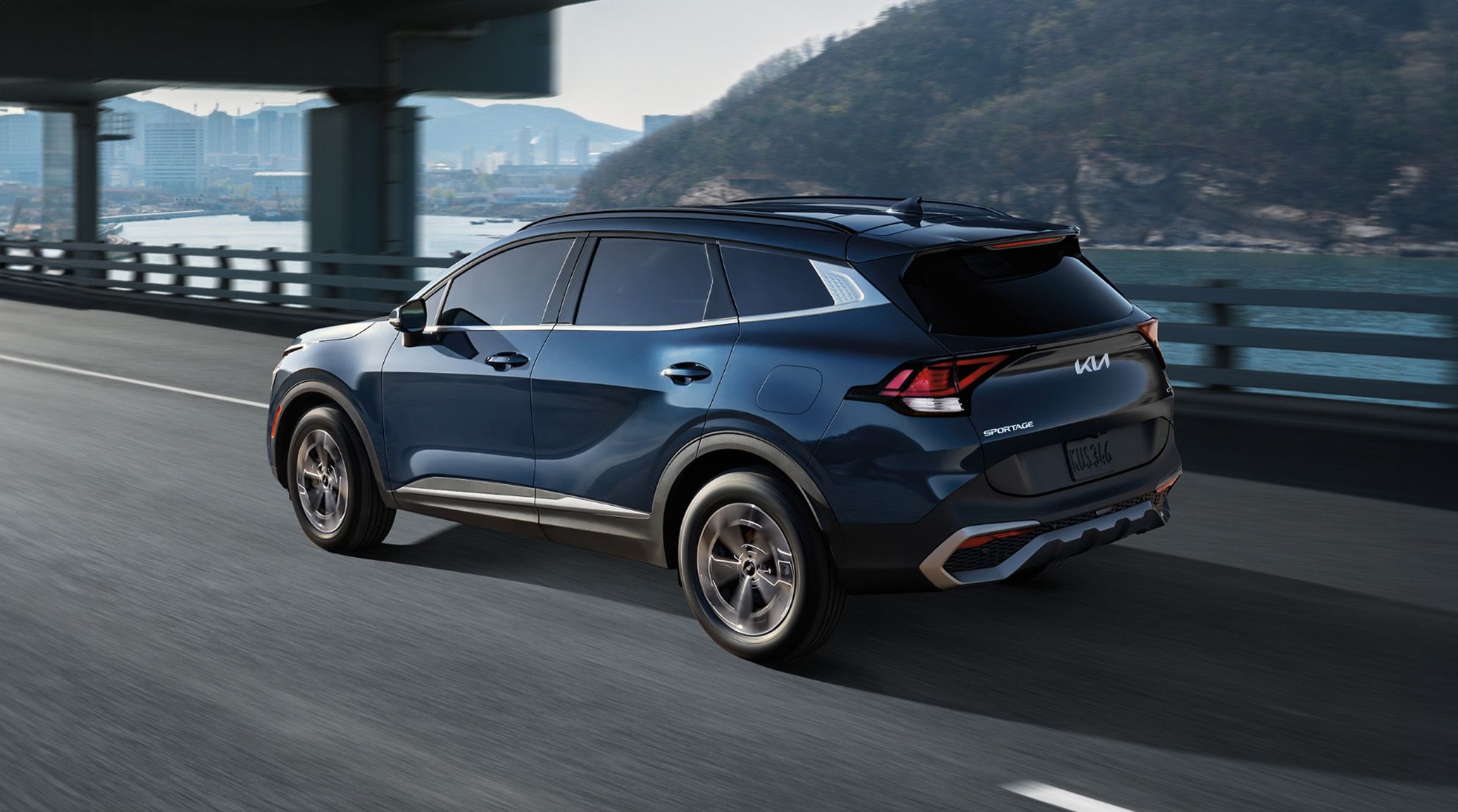 2024 Sportage Hybrid EX and SX Prestige driviing on highway by river. 