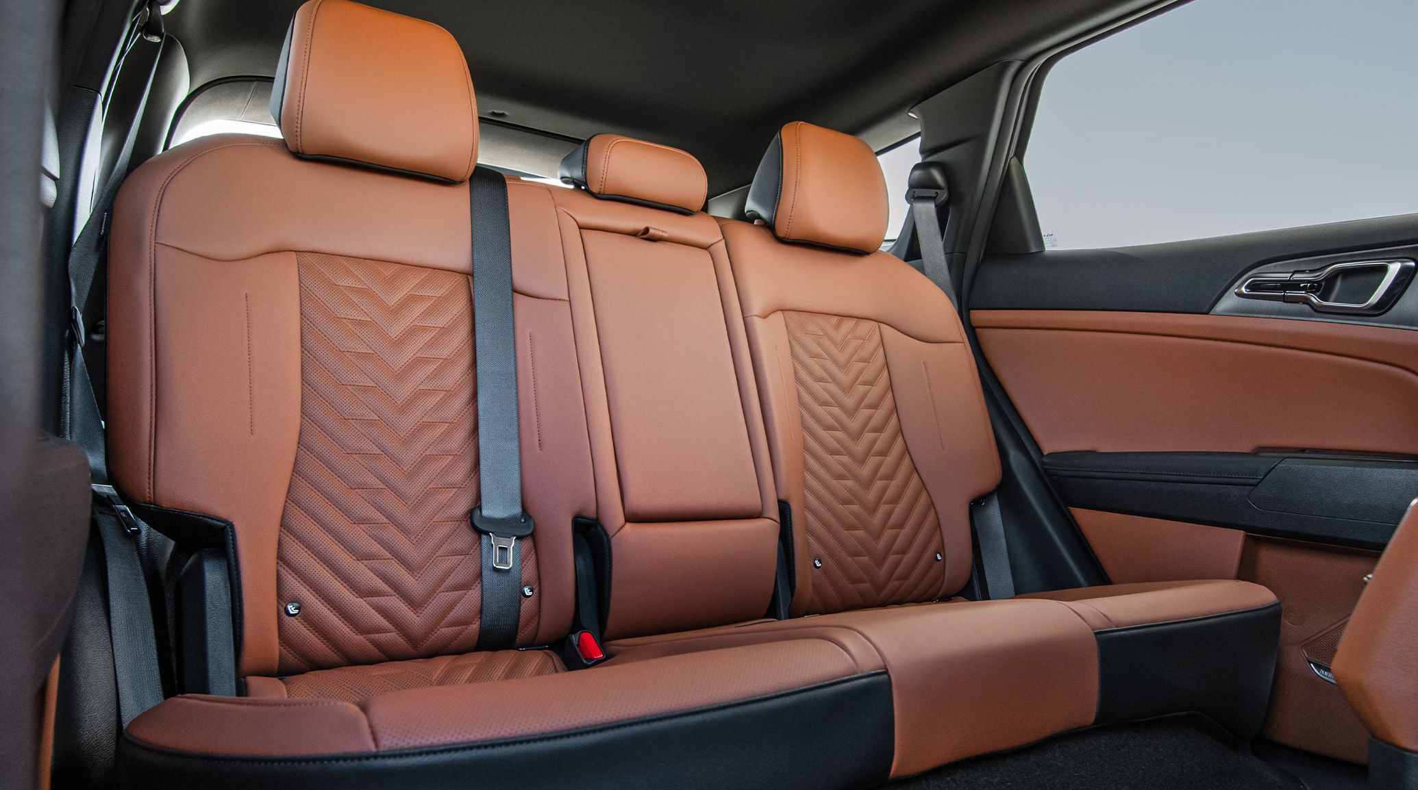 2027 Kia Sportage Hybrid rear seating area in brown featuring quilted brown SynTex upholstery, three headrests, and showcasing the class-leading rear seat legroom.