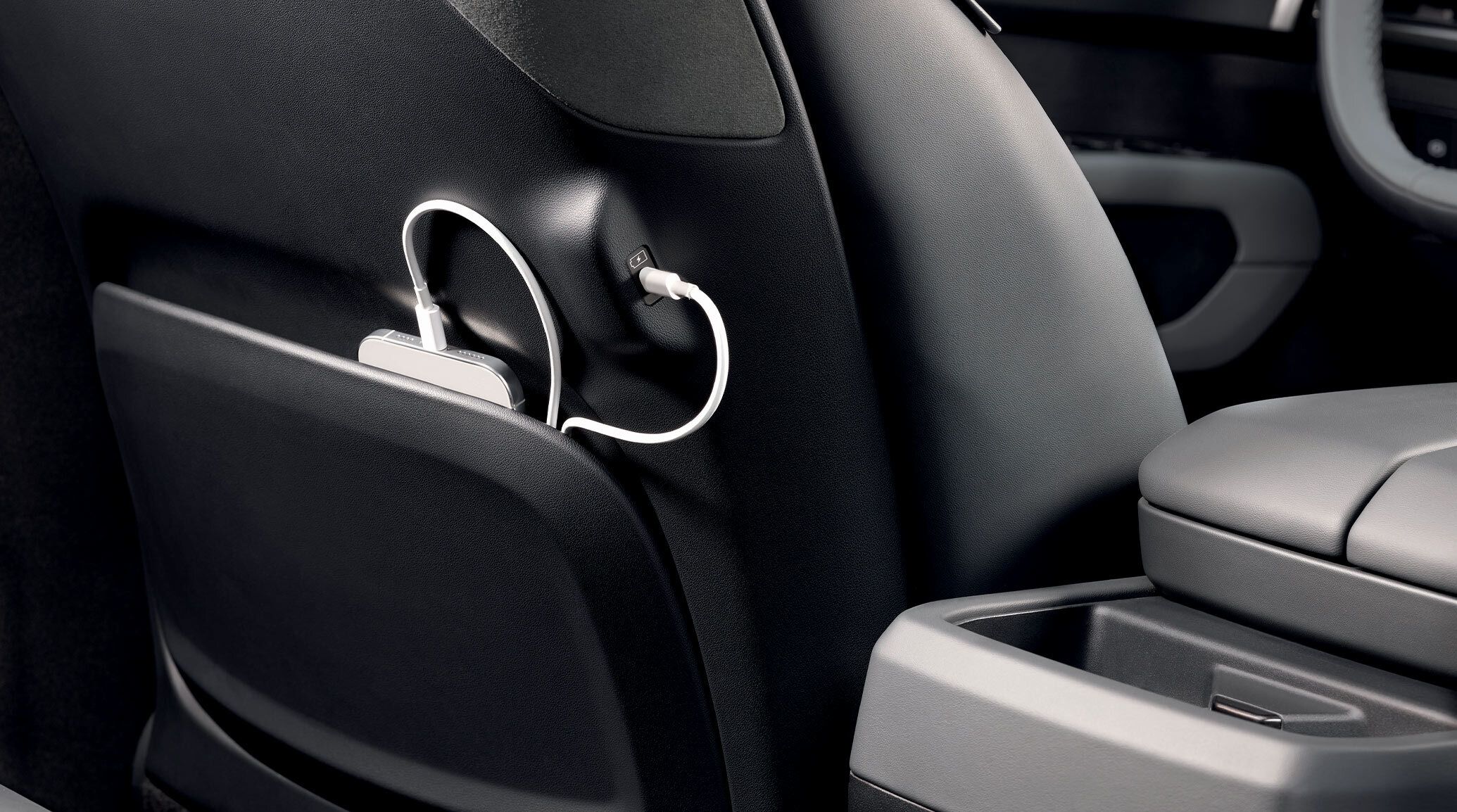 A close-up shot of the black rear of the 2027 Kia Telluride Hybrid, highlighting the spacious trunk with a reusable water bottle on the back cupholder and a bag stored in the back.