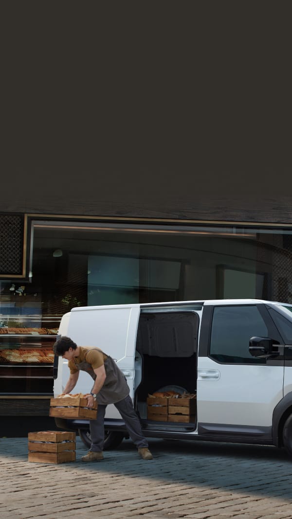 Worker unloading bread crates from the Kia PV5 Cargo side door