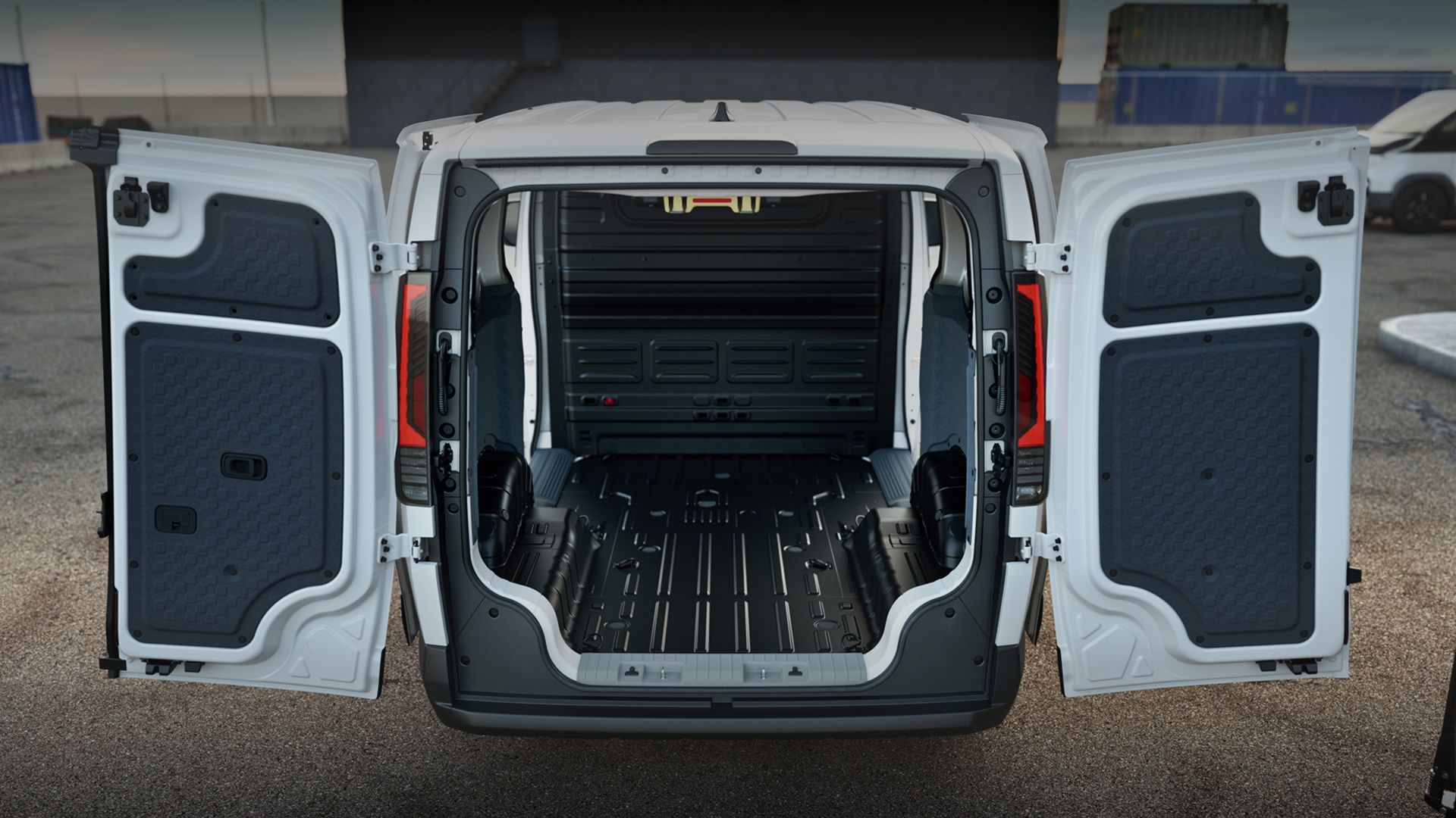 Female worker carrying toolbox beside the Kia PV5 Cargo with rear storage open