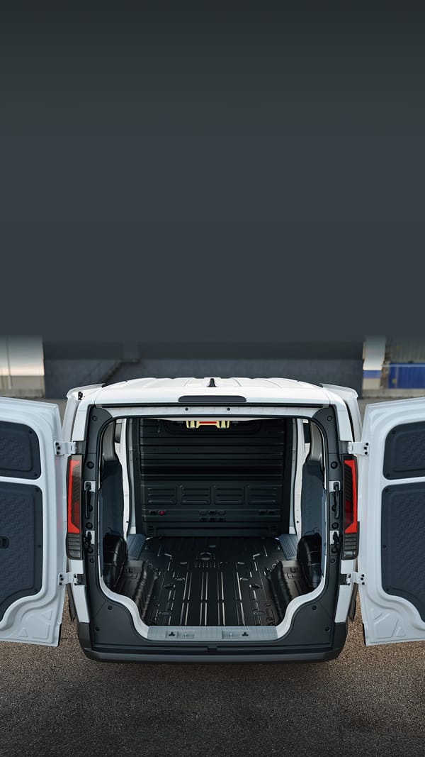 Female worker carrying toolbox beside the Kia PV5 Cargo with rear storage open