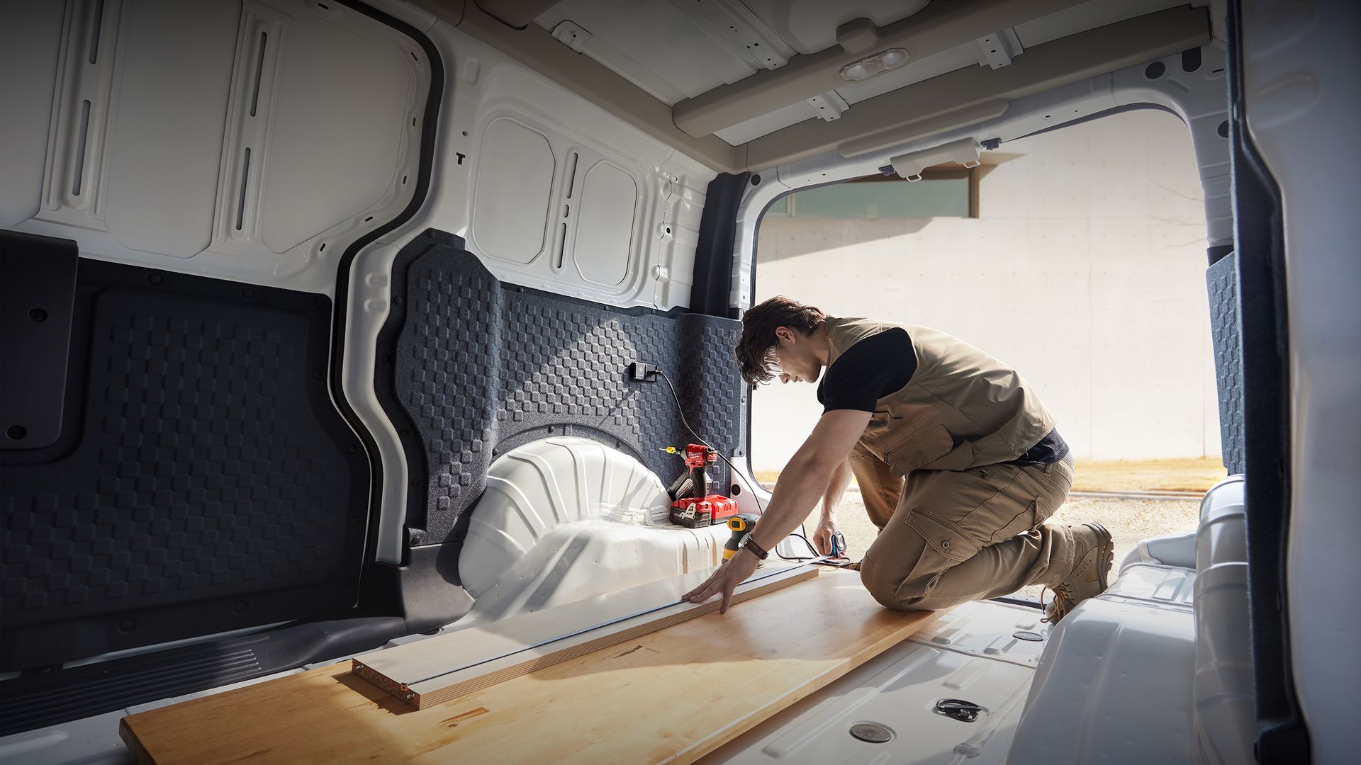 The Kia PV5 Cargo interior shown with tools and equipment for illustrative purposes.