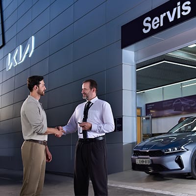 Kia mağazasının qarşısında insanlar danışır.