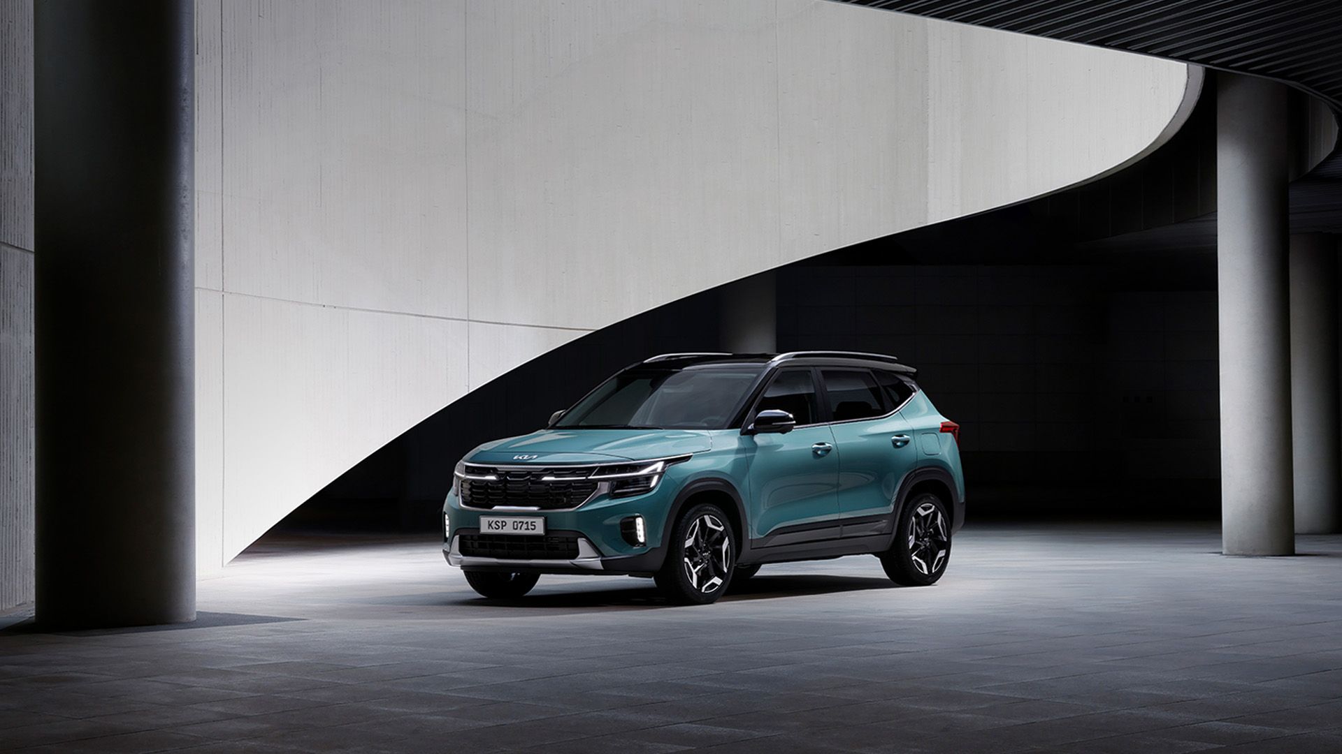 Vista lateral frontal de los Seltos estacionados frente a una estructura geométrica