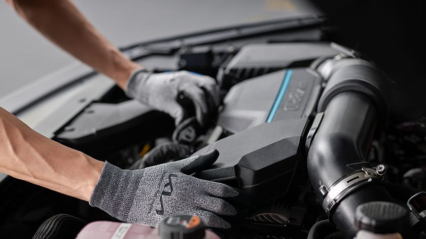 Técnico de Kia realizando el mantenimiento del motor híbrido de un Sportage HEV.