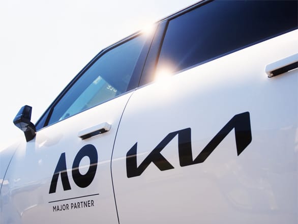 Side view of a Kia vehicle with AO Major Partner branding.