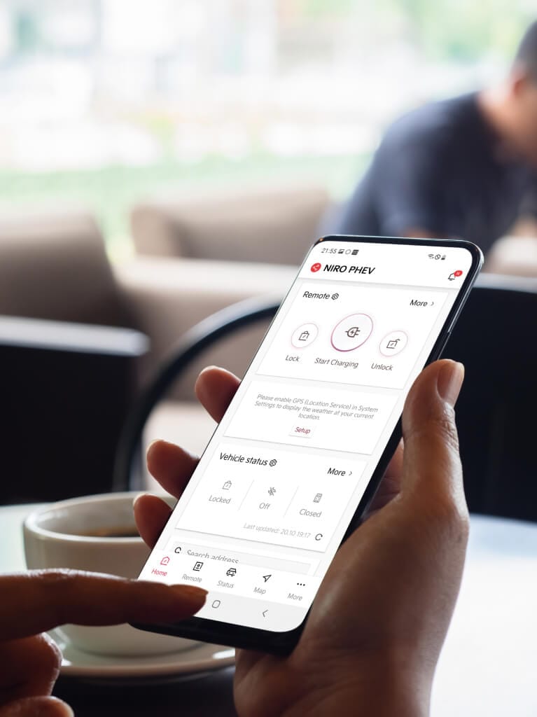 Kia Niro EV, Kia Connect-App, Hände am Mobiltelefon