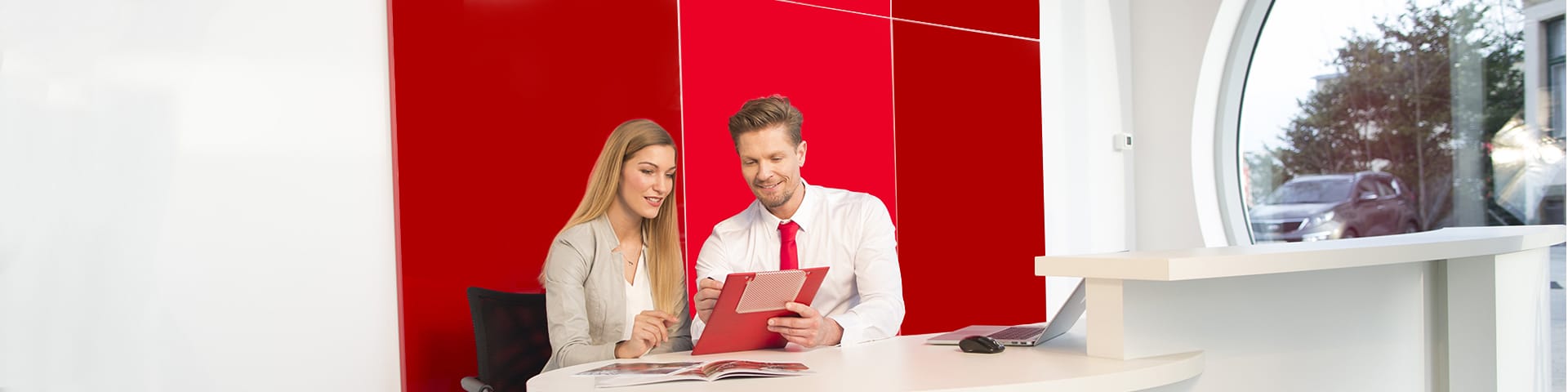 Un conseiller service Kia parle avec une cliente dans une concession. 