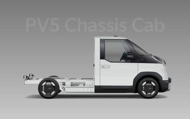 Side view of the two-tone Kia PV5 WAV with accessibility ramp extended