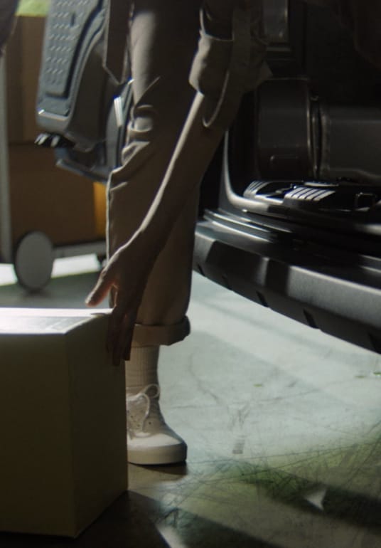 Worker lifting a box beside the low side-door step-in of the Kia PV5 Cargo