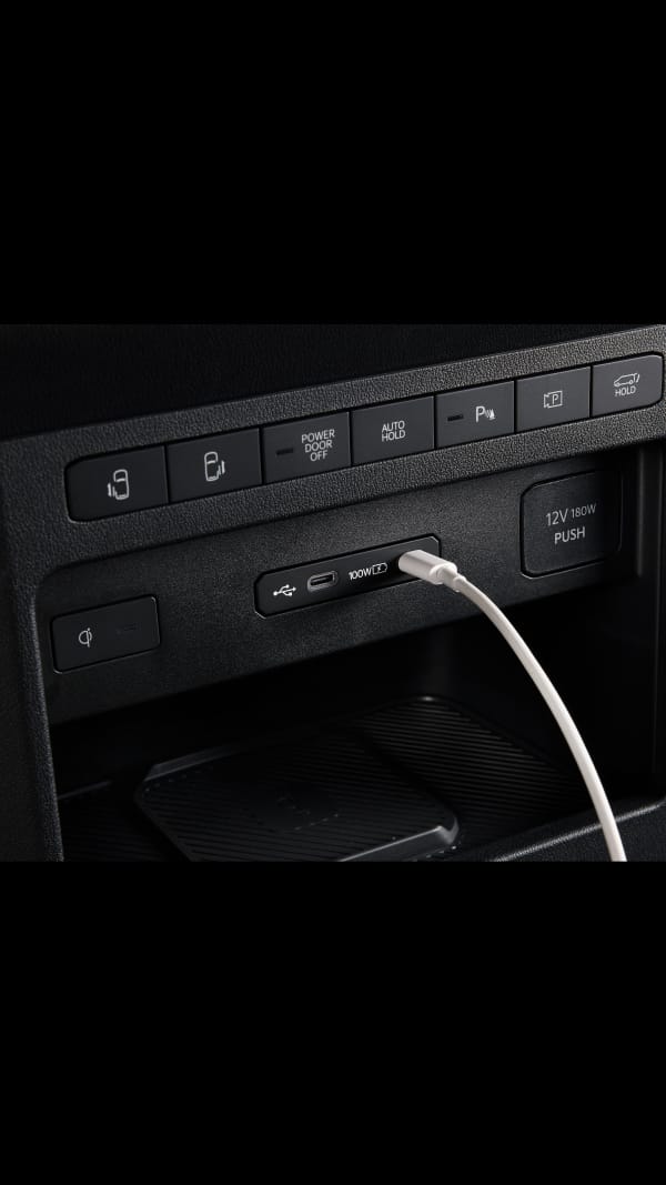 Primer plano del puerto USB del salpicadero del Kia PV5 Cargo con cable conectado