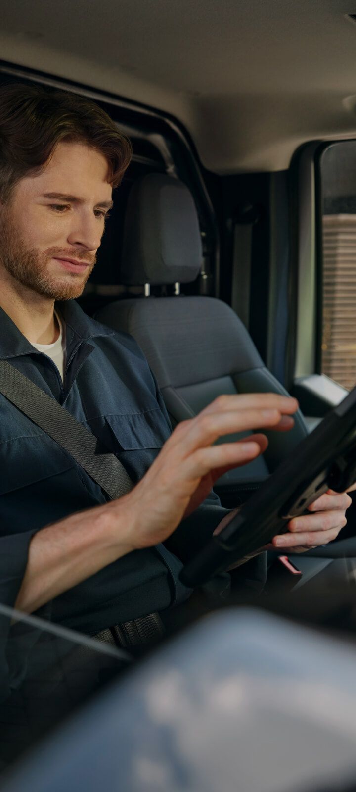 Man interacting with a infotainment system touchscreen in a vehicle