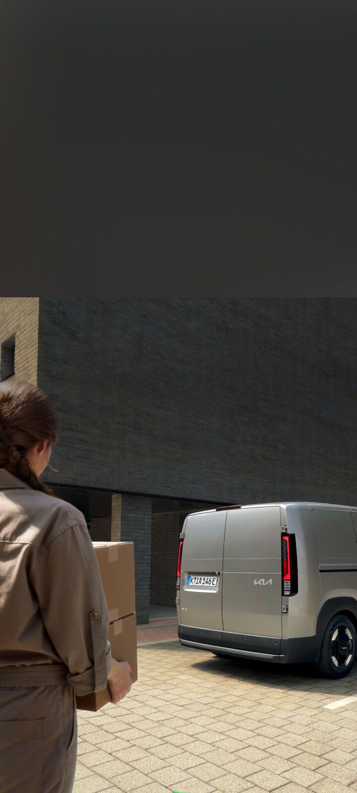 Worker unloading bread crates from the Kia PV5 Cargo side door