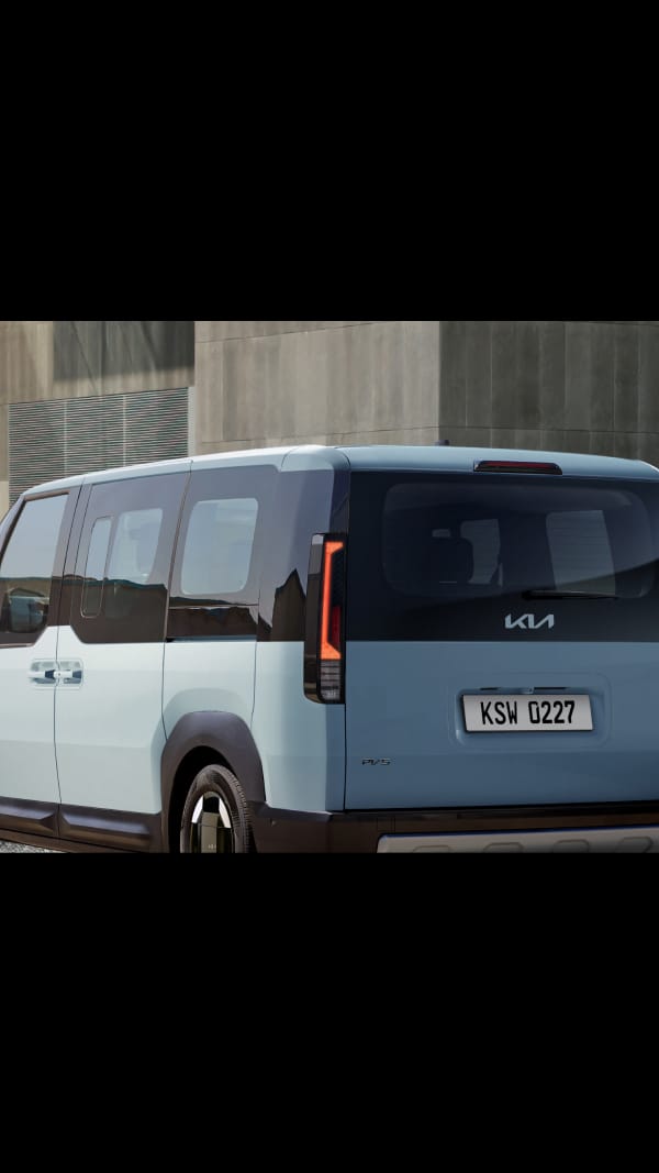 Rear angle view of the Kia PV5 Passenger highlighting vertical tail lamps and wide profile