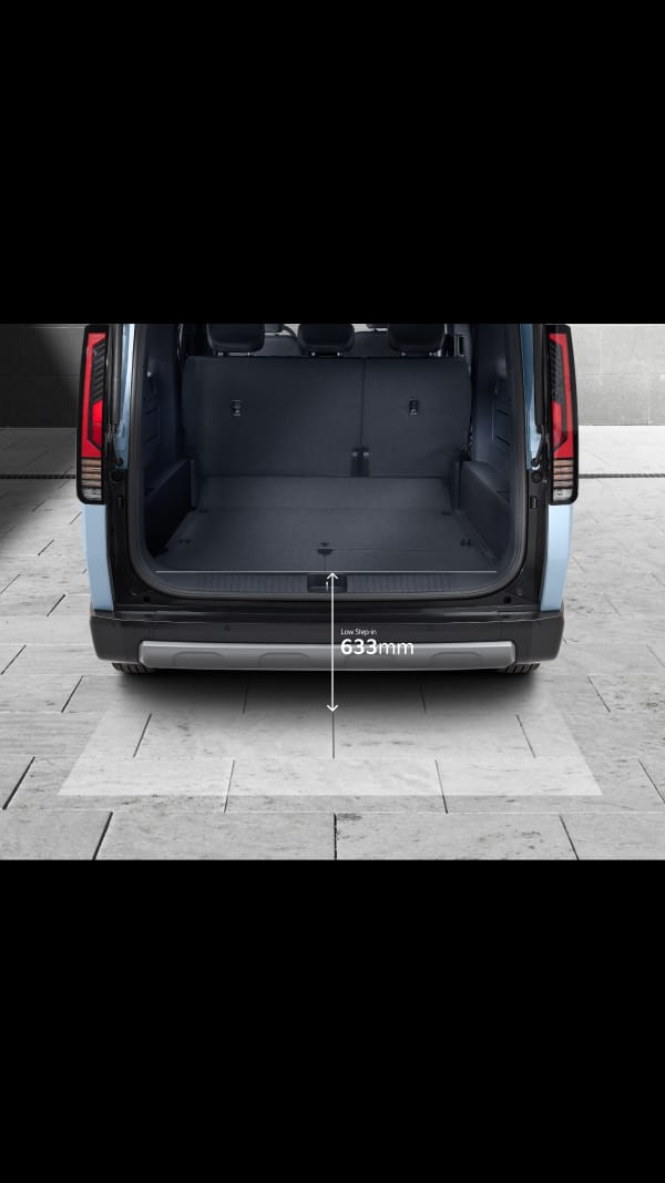 Rear view of the Kia PV5 Passenger with its tailgate open, highlighting a 1,326 mm-wide rear opening and a low 633 mm step height for easy loading of family luggage or business cargo.