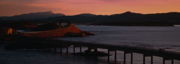 Unscharfe Küstenlandschaft mit einer Brücke bei Sonnenuntergang