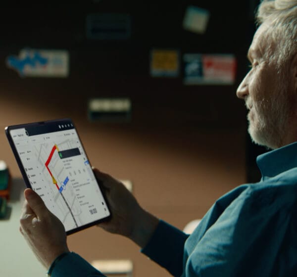 Älterer Mann hält ein Tablet mit Flottenanalyse-Daten