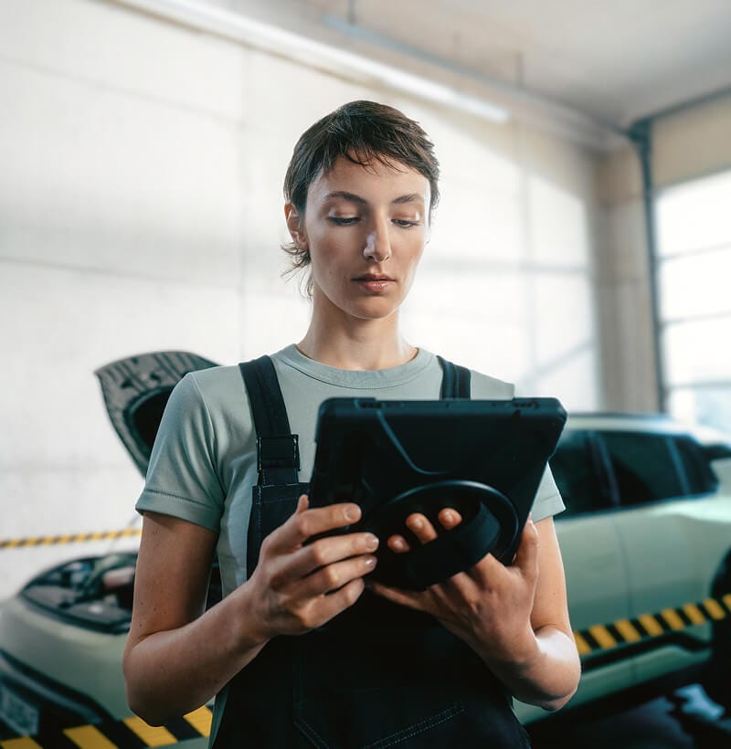 Female Kia technician checks Kia EV3 battery State of Health with a diagnostic device.