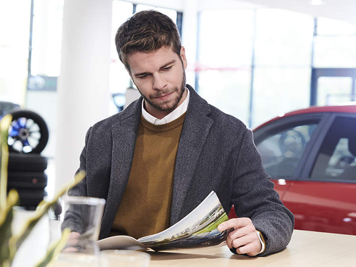 Customers in home environment reading through the Kia Sportage brochure