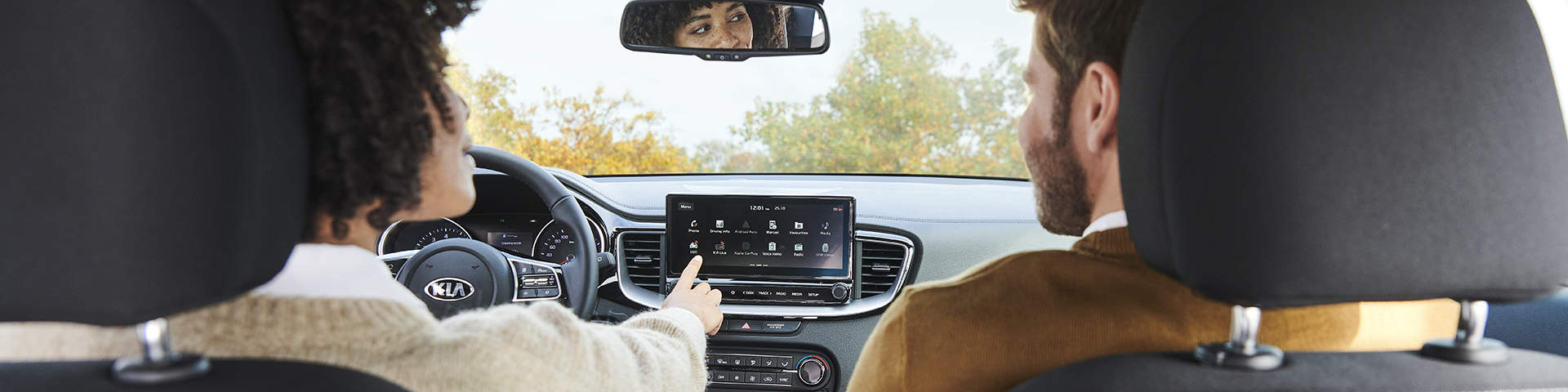 Et par kører en Kia og bruger Kias tjenester på touchscreen.