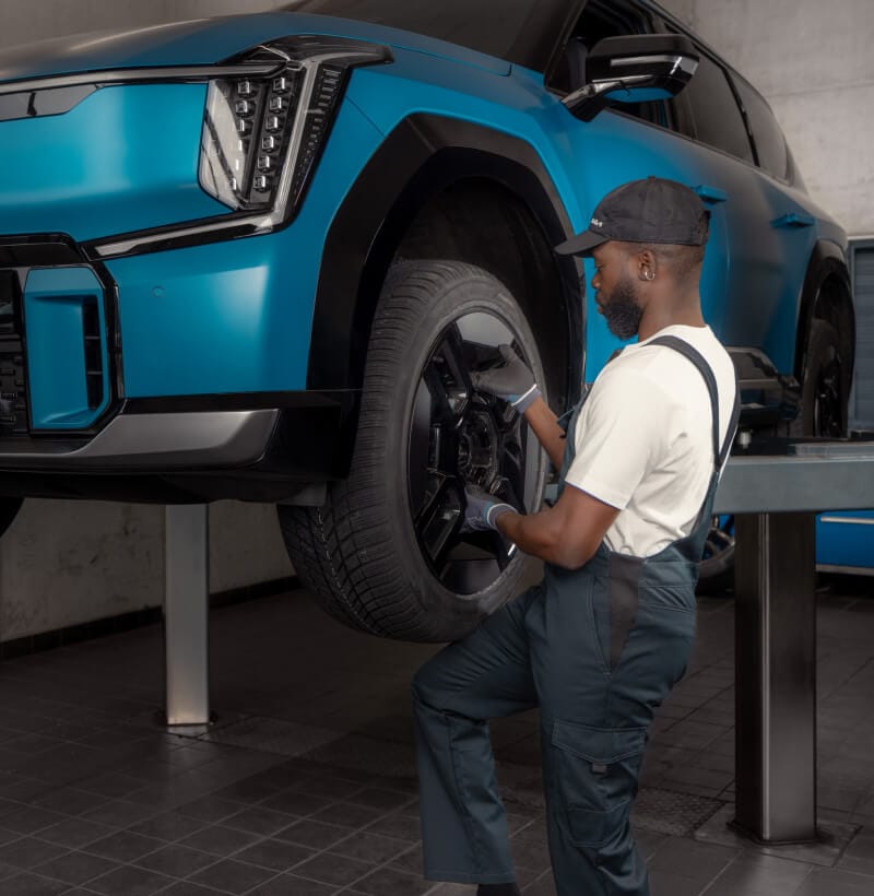 A Kia technician changes the tyres of an Kia EV9.