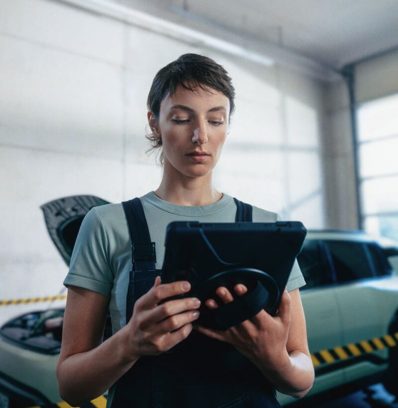 Female Kia technician checks Kia EV3 battery State of Health with a diagnostic device.
