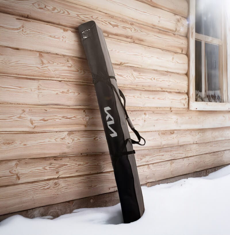 The Kia Ski Bag from the Kia Collection leans against a wodden wall of a mountain hut.