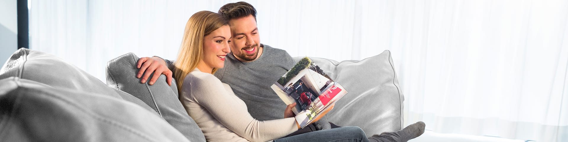 Customers in home environment reading through the Kia Sportage brochure