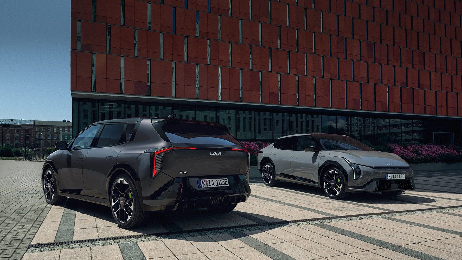 Deux voitures électriques Kia EV4 GT garées sur un parvis pavé